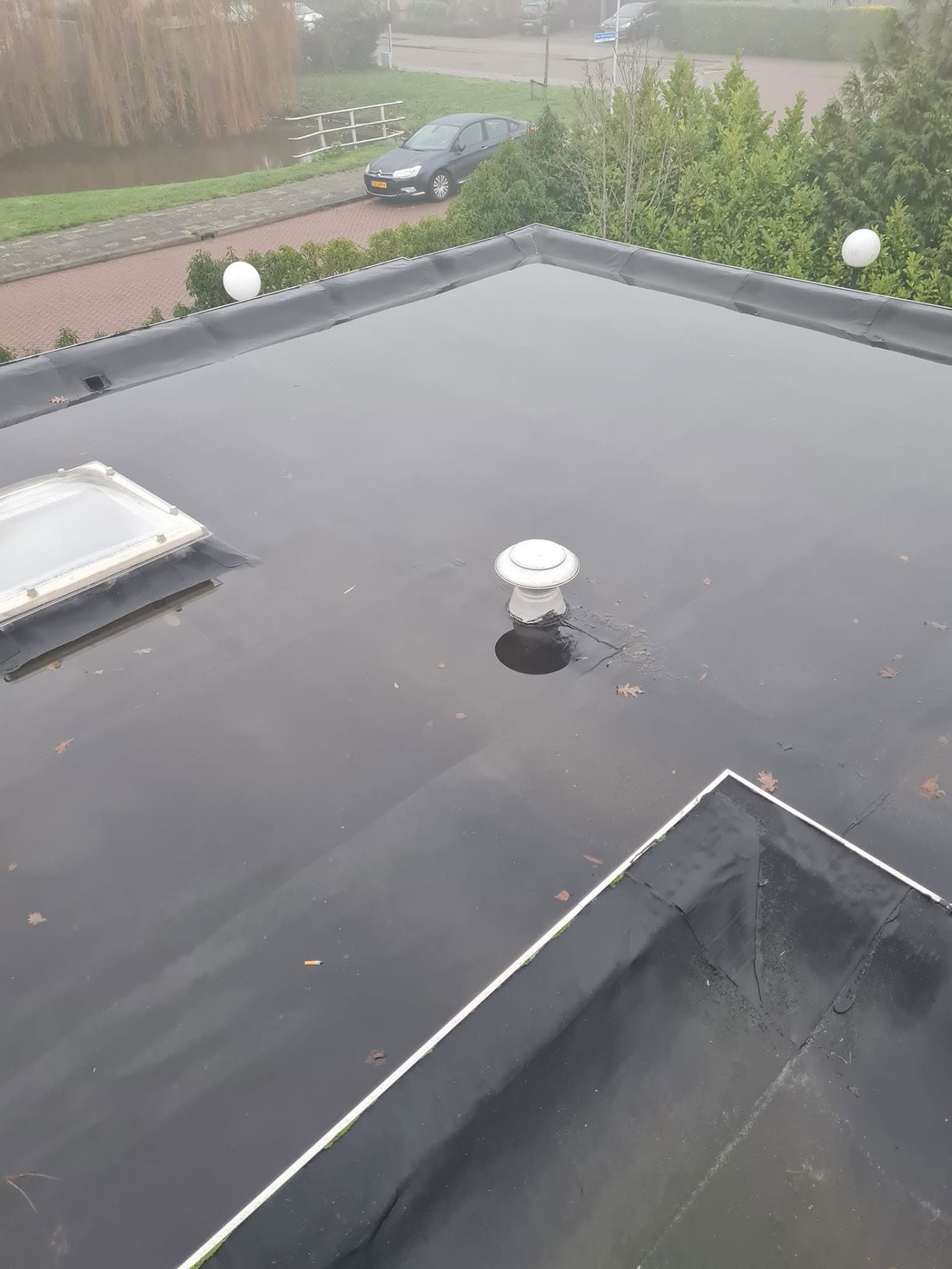 Afgewerkt plat dak met nieuwe dakbedekking, lichtkoepel en dakdoorvoer in Den Haag